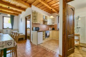 una cucina con mobili in legno e tavolo di Levendula Apartman a Hegykő