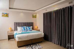 a bedroom with a bed and a window with curtains at Northgate Villa Guest House in Gweru