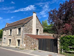 ein Steinhaus mit einem Tor und einer Garage in der Unterkunft Gîte du Moulinet in Chézy-sur-Marne