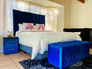 a bedroom with a large bed with a blue headboard at The Qs guest suite in Brakpan +38 photos