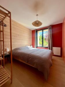 ein Schlafzimmer mit einem großen Bett und einem Fenster in der Unterkunft Gîte du Moulinet in Chézy-sur-Marne