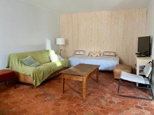 ein Wohnzimmer mit Sofa und Tisch in der Unterkunft Gîte du Moulinet in Chézy-sur-Marne