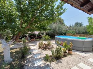 a backyard with a hot tub and some plants at House Konstantinos in Agios Georgios