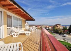 a balcony with white furniture and a view of a city at Manolovi Guest House in Obzor