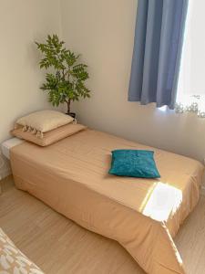 ein großes Bett in einem Zimmer mit einer Pflanze darauf in der Unterkunft Gîte des Papillons & Brocante in Pouzilhac