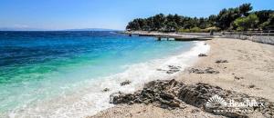 a beach with a pier and the blue water at Relaxed Getaway by the Sea in Trogir