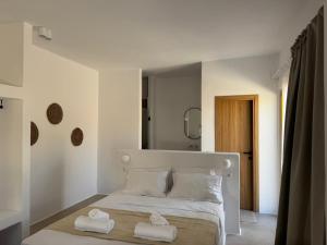 a white bedroom with two towels on a bed at Antiparos Gems in Agios Georgios +45 photos