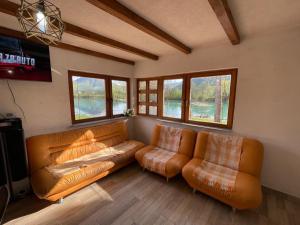 a living room with two leather couches and a television at Una Dreams in Bare