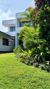 a house with a yard with green grass and plants at Coastal Cloud in Hikkaduwa