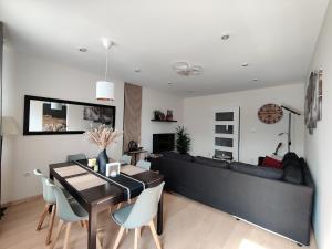 ein Wohnzimmer mit einer Couch und einem Tisch und Stühlen in der Unterkunft Saujana House - Peaceful Borderside Retreat in Mosonmagyaróvár