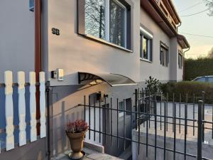 ein Haus mit einem Zaun und einer Vase davor in der Unterkunft Saujana House - Peaceful Borderside Retreat in Mosonmagyaróvár