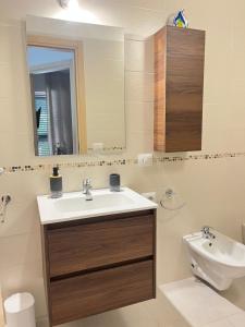 a bathroom with a sink and a toilet and a mirror at Villa Costa del Sole - Capitolo in Monopoli