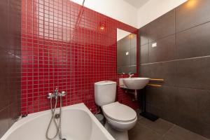 a red tiled bathroom with a toilet and a sink at Sea waves - Olhão in Olhão +25 photos