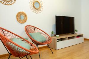 a living room with two chairs and a television at Sea waves - Olhão in Olhão