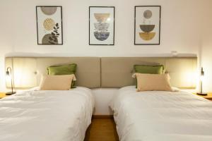 two beds sitting next to each other in a bedroom at Sea waves - Olhão in Olhão