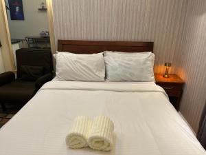 a hotel room with a bed with two towels on it at Studio unit inside IT Park Wifi & Netflix in Cebu City