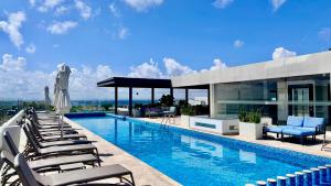 a swimming pool with lounge chairs and a building at Ipana Luxury Suites By Caribe Rentas in Playa del Carmen