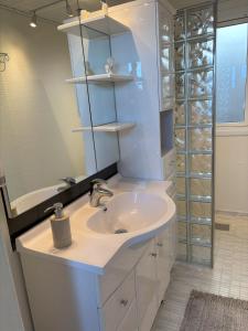 a white bathroom with a sink and a shower at Feriebolig smukt beliggende i vandkanten in Munkebo