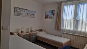 a room with two beds and a window at Banjica 202 in Voždovac +13 photos