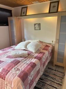 a bedroom with a bed with a blanket and a rug at Feriebolig smukt beliggende i vandkanten in Munkebo