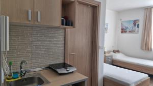 a kitchen with a sink and a bed in a room at Banjica 202 in Voždovac