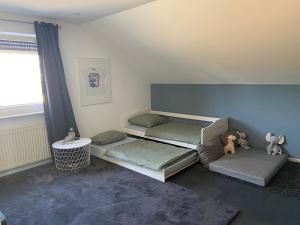 a room with two beds and a table and a window at Wohlfühlzeit Weinheim in Weinheim
