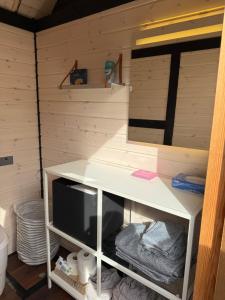 Un escritorio blanco con un televisor en una habitación. en Happy Mermaid Garden Cabin, en Aalborg