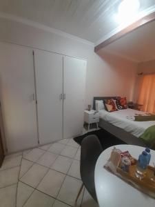 Habitación con 2 camas, mesa y mesa. en TANS Guest suite, en Centurion
