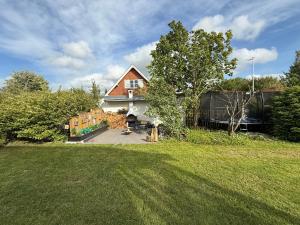 una casa con un patio con césped en Happy Mermaid Garden Cabin, en Aalborg