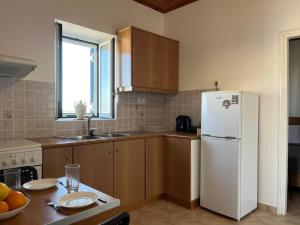 a kitchen with a white refrigerator and a table at Zhanna House in Karvounádhes