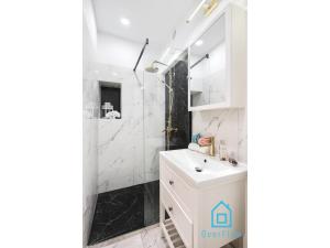 a bathroom with a white sink and a shower at Exclusive Apartment at Old Town Gdansk in Gdańsk