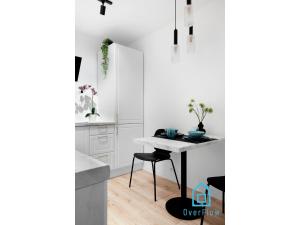 a white kitchen with a table and chairs at Exclusive Apartment at Old Town Gdansk in Gdańsk