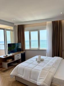 a bedroom with a large white bed and windows at Gent's Inn Luxury in Durrës +64 photos