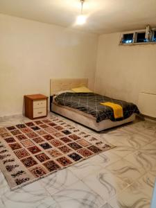 a bedroom with a bed and a rug on the floor at The cheapest room closest to Istanbul airport in Arnavutköy