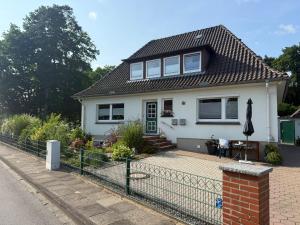 a white house with a fence in front of it at Haus Lönsweg in Bad Bevensen