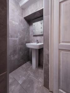 a bathroom with a sink and a mirror at The Courtyard Lodge in Hitchin