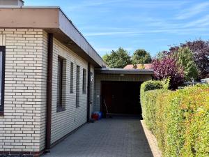 a brick building with a garage with a driveway at Bungalow Löwenstrom in Büsum
