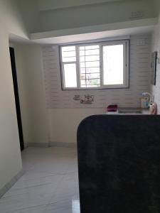a white kitchen with a sink and a window at Cozy Nest - Designed for All in Pune