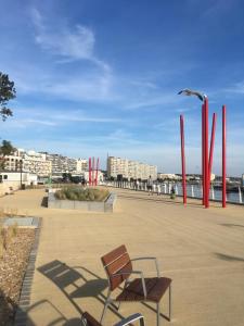 un banc assis sur un trottoir près de l'eau dans l'établissement Au quai 34 appartement, à Boulogne-sur-Mer
