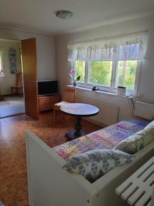 ÅsarpにあるStuga vad vattenのベッドとテーブルと窓のある寝室