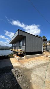 a black house sitting on the side of a lake at Alta Vista Pino Huacho in Valdivia
