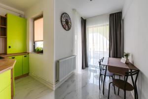 a kitchen with a table and a clock on the wall at Zig-Zag 17 apartment in Constanţa
