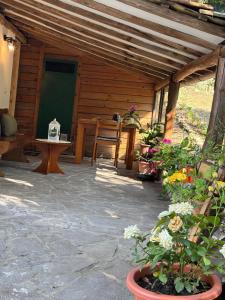 een patio met een houten hut met een tafel en bloemen bij Cozy house in the Chianti region in Castelnuovo Berardenga
