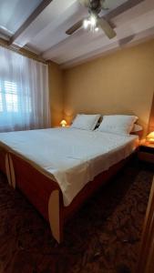 a large bed in a bedroom with a ceiling fan at Family apartment in old town in Cres
