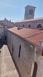 a brick building with a tower on top of it at Family apartment in old town in Cres
