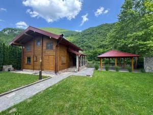 a log cabin with a gazebo in a field at Villa Lavanda in Banja Luka
