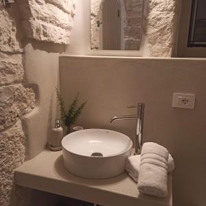 a bathroom with a white sink and towels on a counter at Il Trullo di Betta in Alberobello