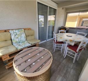 a living room with a couch and a table at chalet typique 50 m de la mer in Gruissan