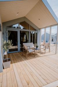 a wooden deck with a table and chairs on a house at Domki Morska Olivka in Puck