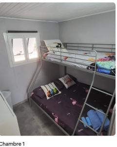 a room with two bunk beds and a window at chalet typique 50 m de la mer in Gruissan